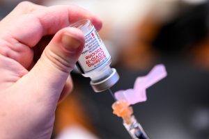 Needle pulling vaccination serum out of vial