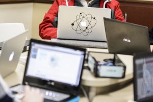 An undergraduate's Apple laptop computer, decorated with a graphic of circling atoms, is pictured.